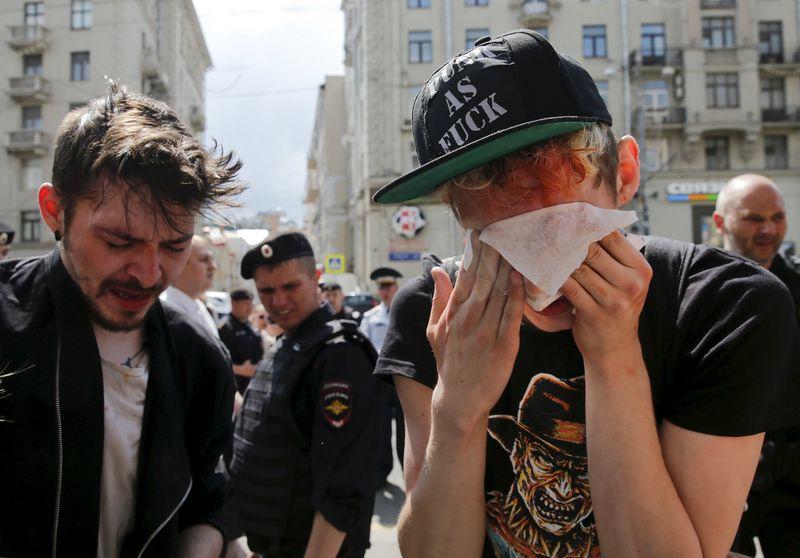 Gay rights activists react after being pepper sprayed by anti-gay protesters during an LGBT (lesbian, gay, bisexual, and transgender) community rally in central Moscow